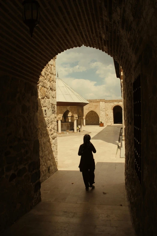 a person with a suitcase walking through a tunnel