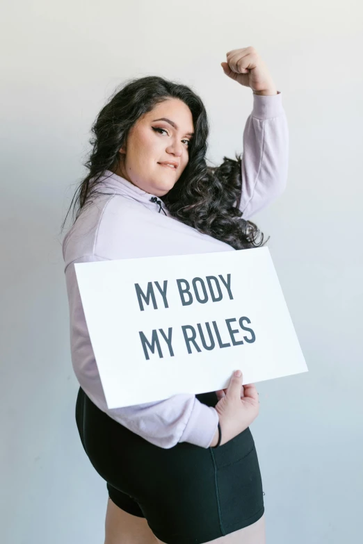 a woman holds up her sign and poses for a picture
