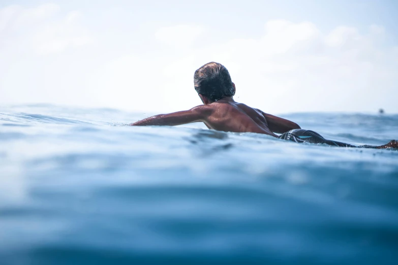 a person floating on top of a surfboard in the ocean