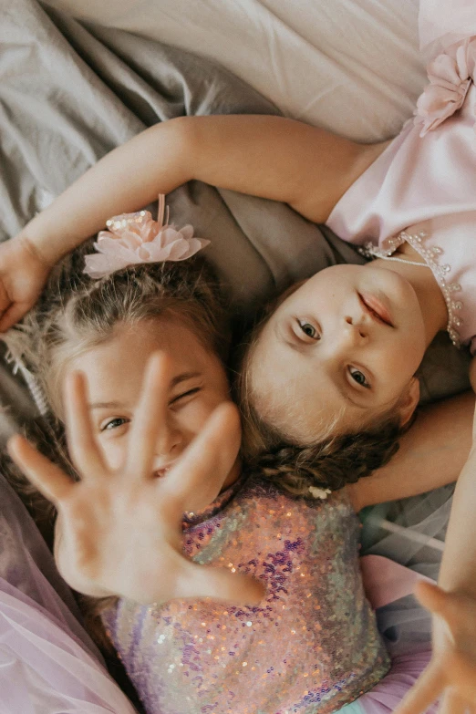 two children on a bed posing for the camera