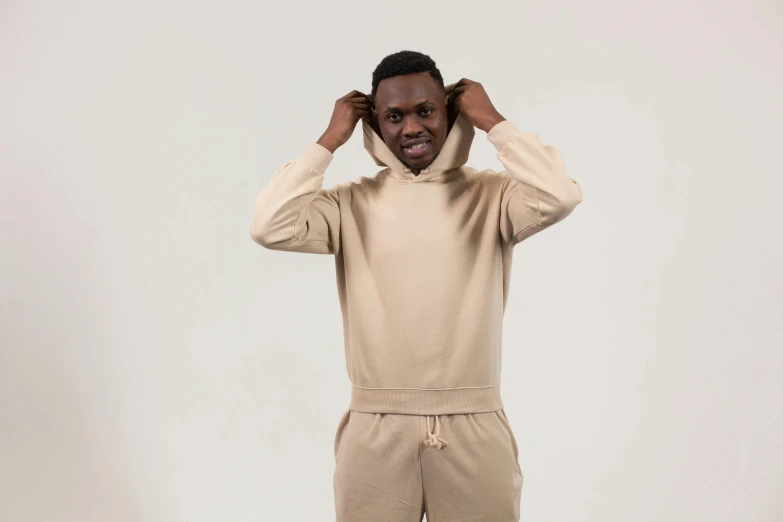 an african american man with a hooded sweatshirt and sweat pants on poses for a picture