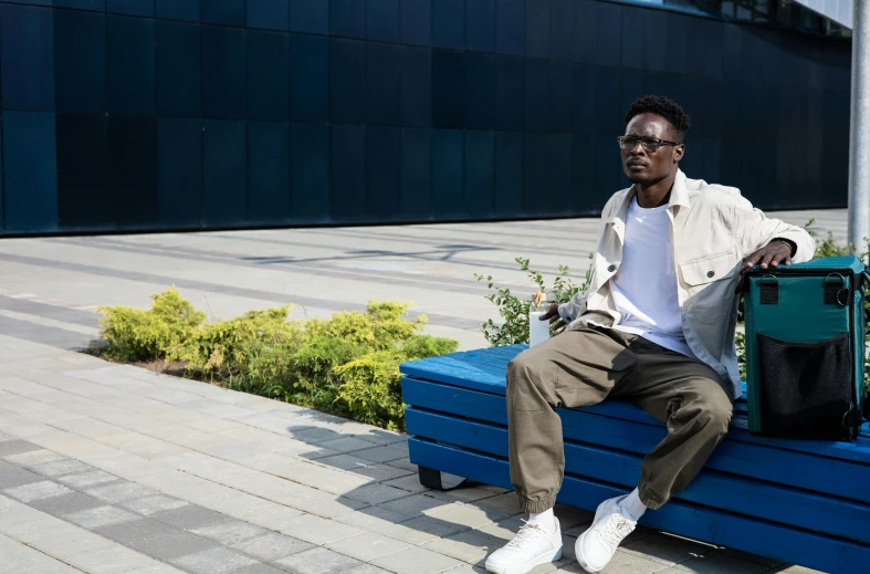 a man sitting on a bench outside in front of a building