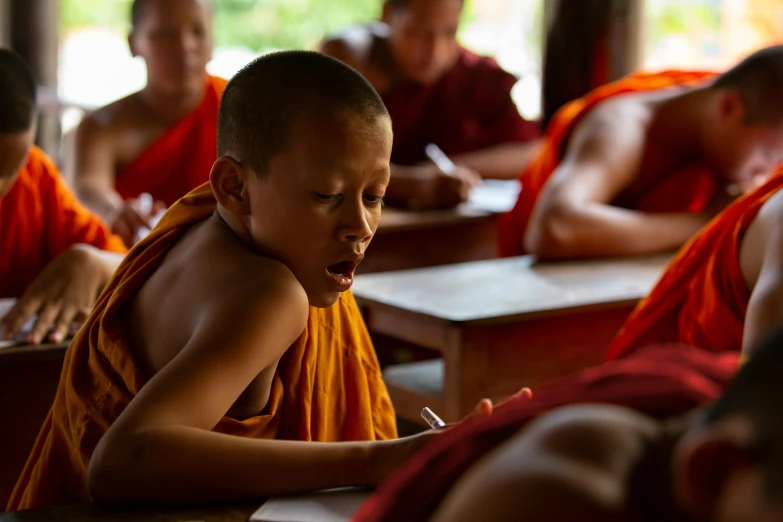 a boy sits at his desk writing a task