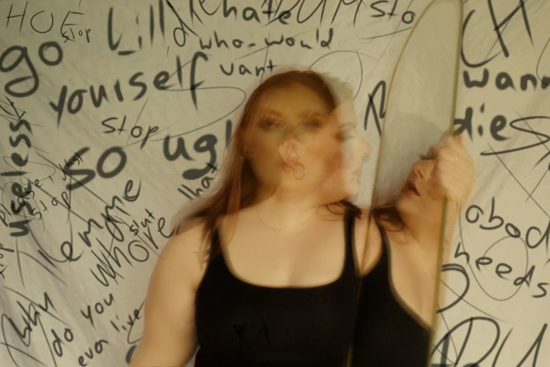 woman standing in front of graffiti covered wall