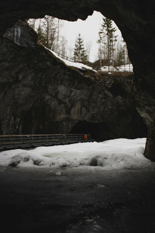 an ice covered rock cave with the light showing through