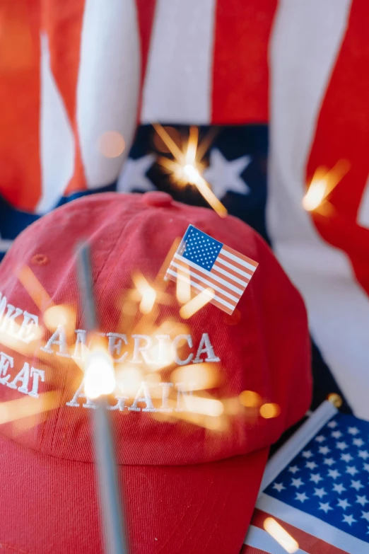 a red hat is laying on top of an american flag