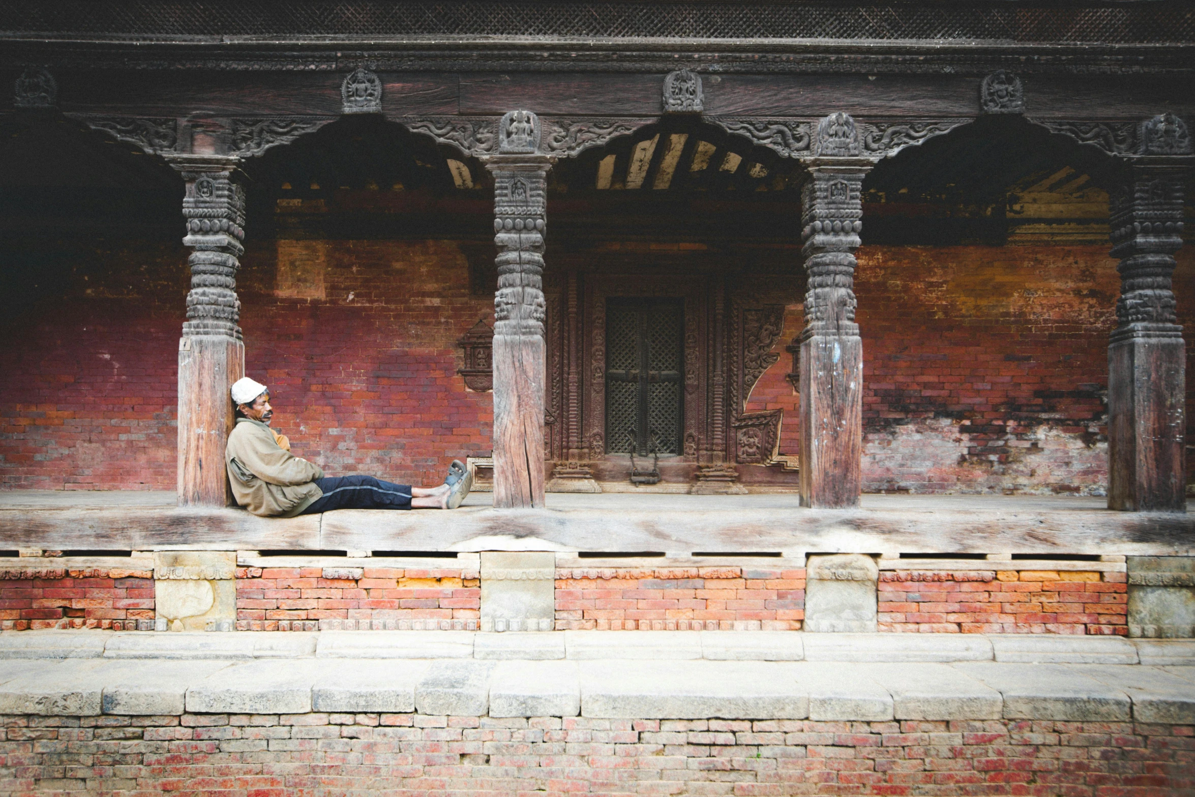 a person sitting on a wall and some brick pillars