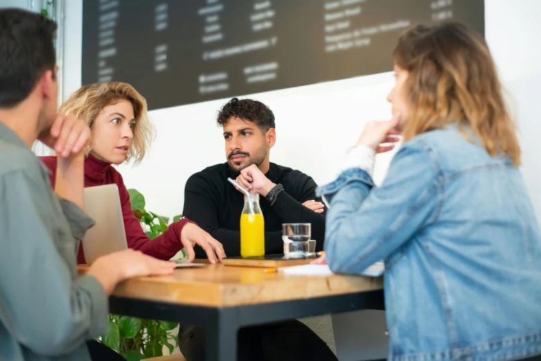 some people are sitting at a table in a cafe