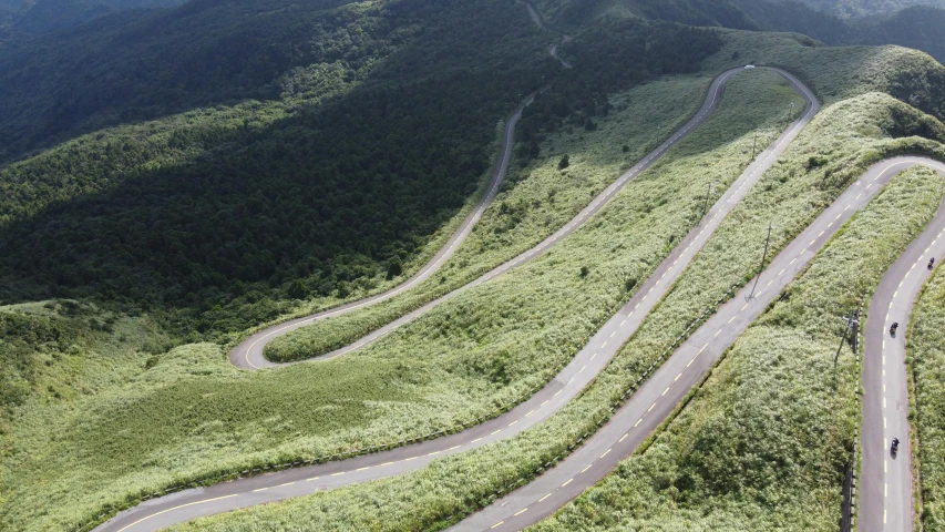 the winding road curves through green mountain sides