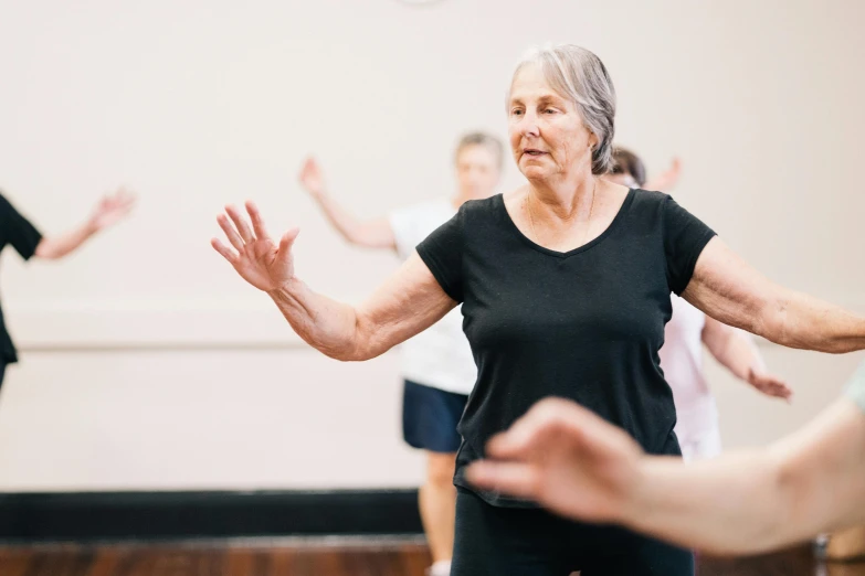 older people in gym doing yoga exercises for elderly women