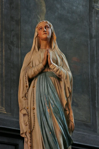 a statue of the immaculate mary holding hands