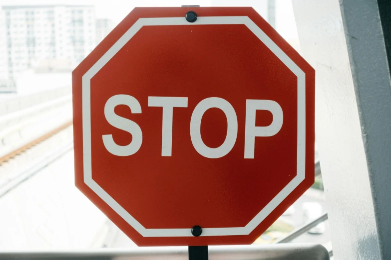 a stop sign hanging from a metal rail