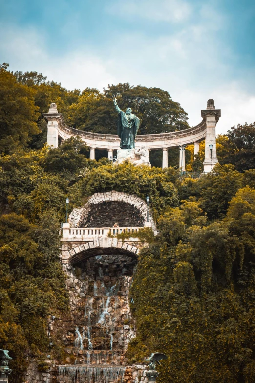 the statue is on top of a cliff and has statues on it