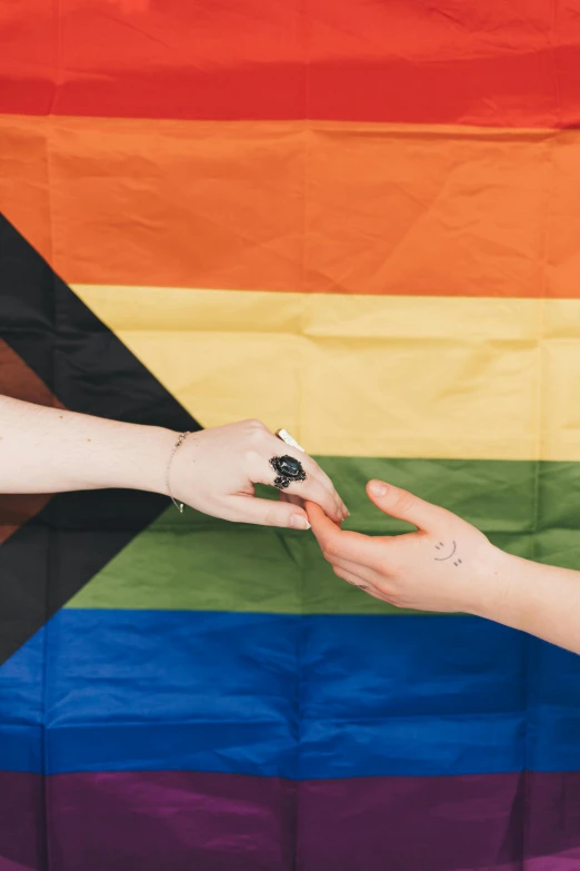 a woman's hand handing over a cigarette to another woman