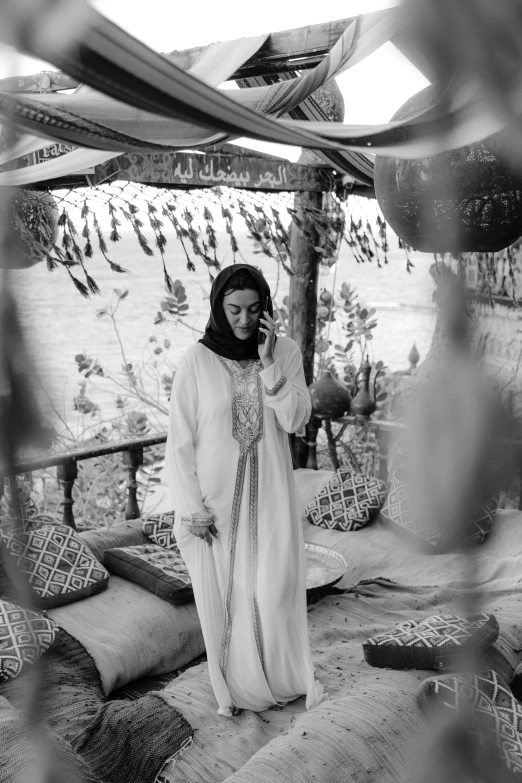 a woman with a cell phone standing near an umbrella