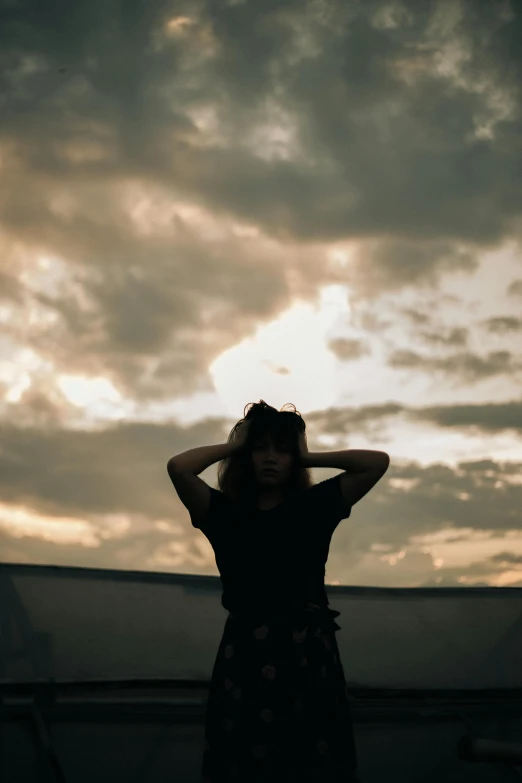 a person standing in front of a cloudy sky