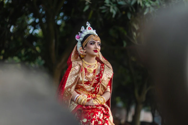 woman in a indian bridal attire looking at soing