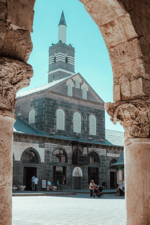 an archway and building with a clock tower in the background