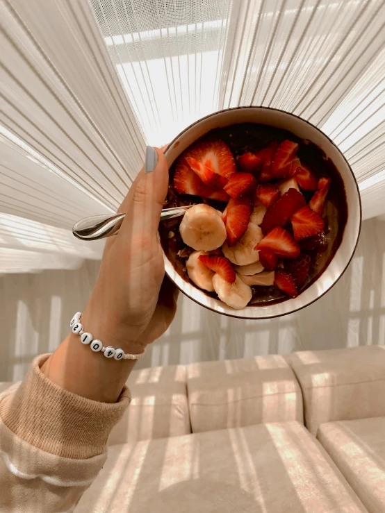 the bowl of strawberries is being held up by a woman