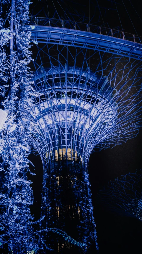 the illuminated christmas tree beneath the large structure is blue