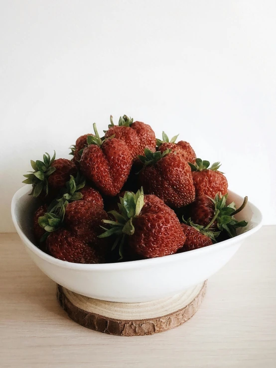 a bowl of strawberries on top of a table