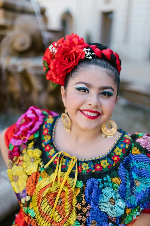 a woman wearing a colorfully decorated outfit in an old town