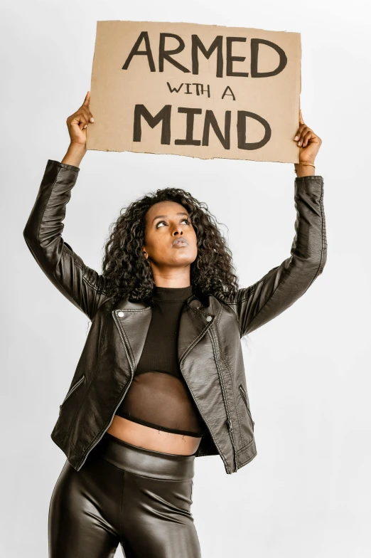 a woman holding a sign that says armed with a mind