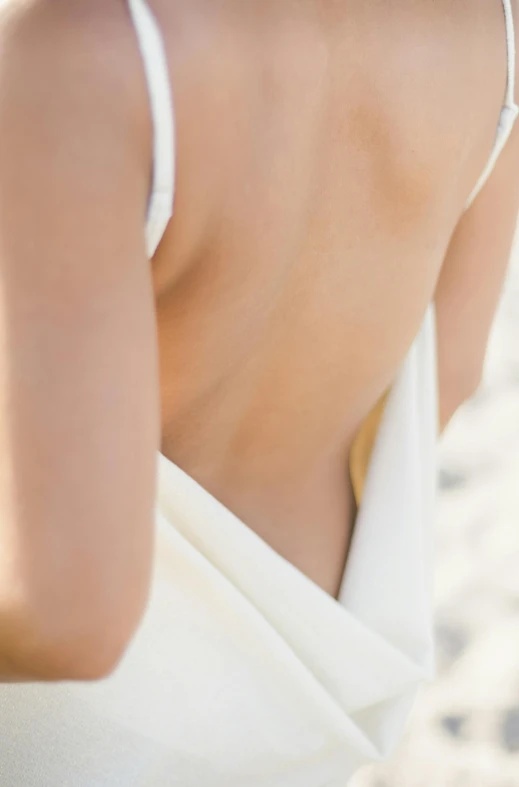 a woman with a white top is posing on the beach