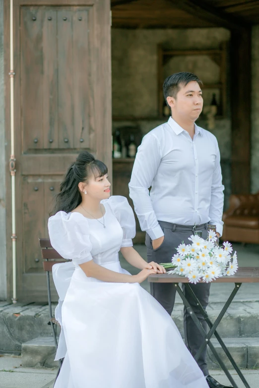 a man standing near a woman in a white dress