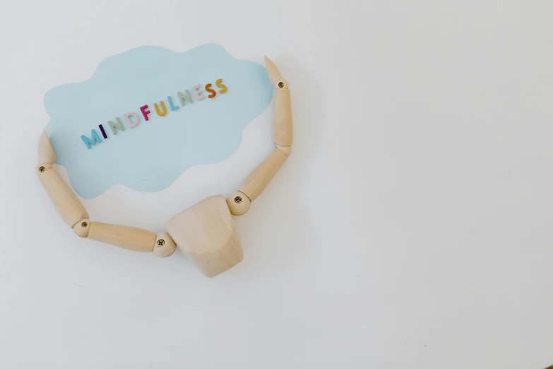 a wooden dummy with the word mindfulness spelled on it