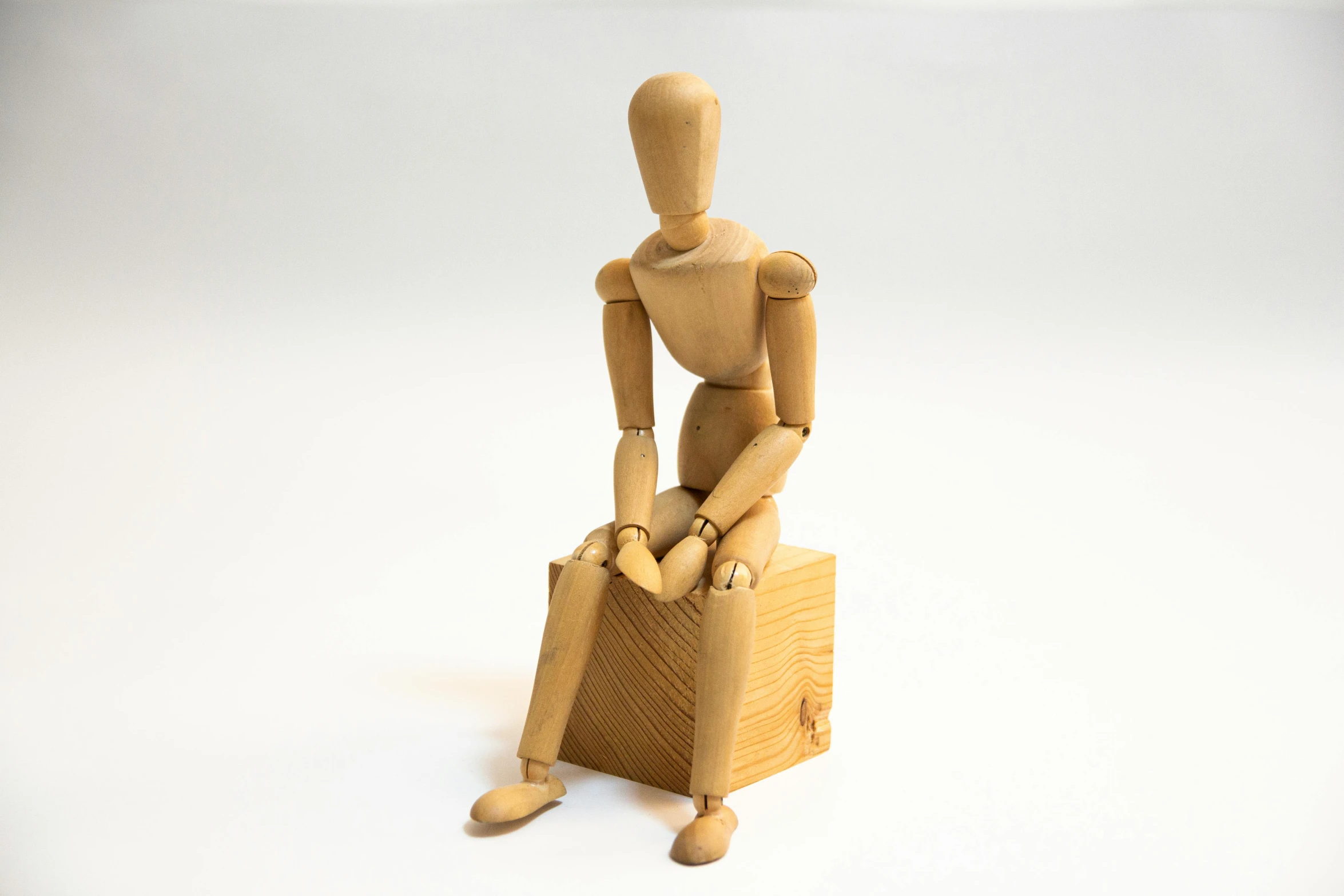 a wooden toy sits in a chair made of wood