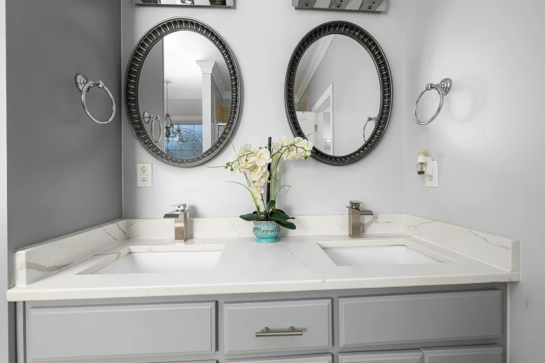 a bathroom with two mirrors and some sinks