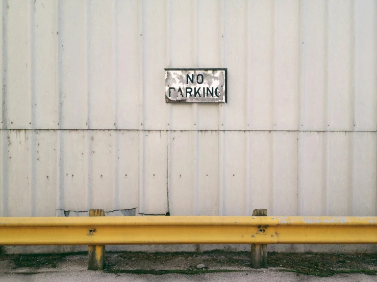 a white wall with no parking sign on it