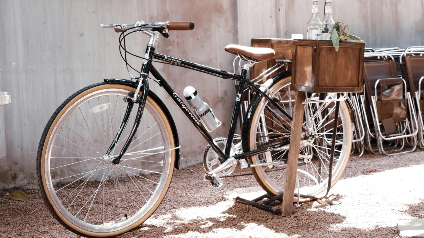 a bike leaning against a wooden table outside