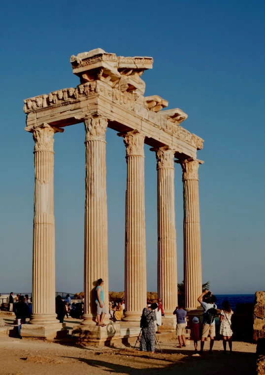 the people are standing at some tall pillars