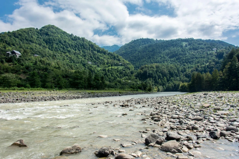 a view from the river in front of some mountains