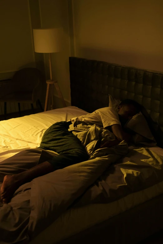 a man lays on a bed that's lit up at night