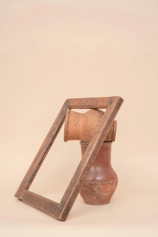 an old vase and small broken frame sitting in the middle