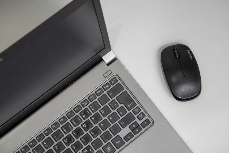 a black and white po of a wireless mouse and a laptop keyboard