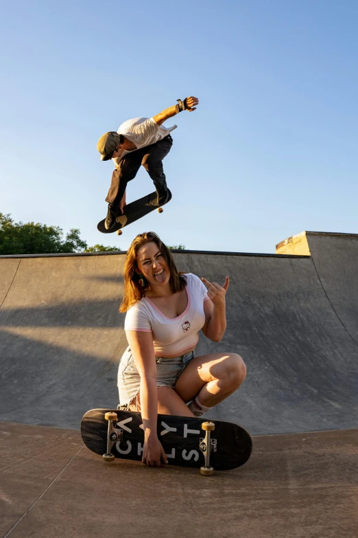 a man doing a trick with his skateboard and a woman