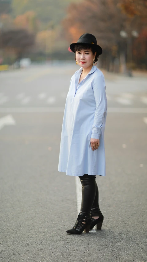 a woman wearing black leather pants and a light blue jacket