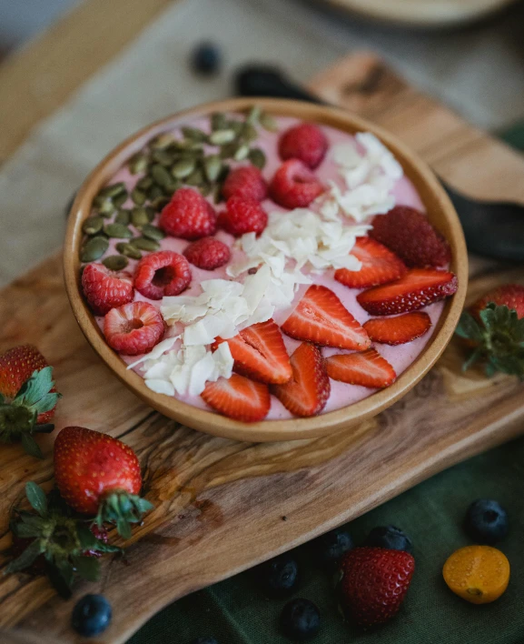 fresh fruits, including strawberries and cream, sit on a  board