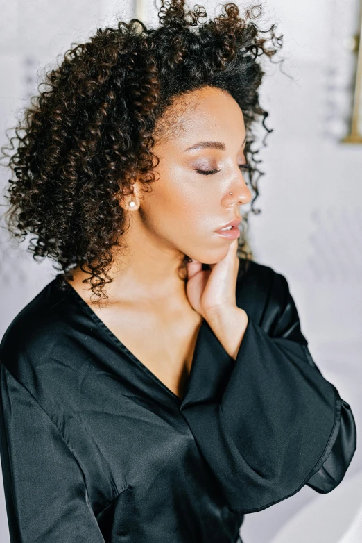 a woman with curly hair wearing a black top