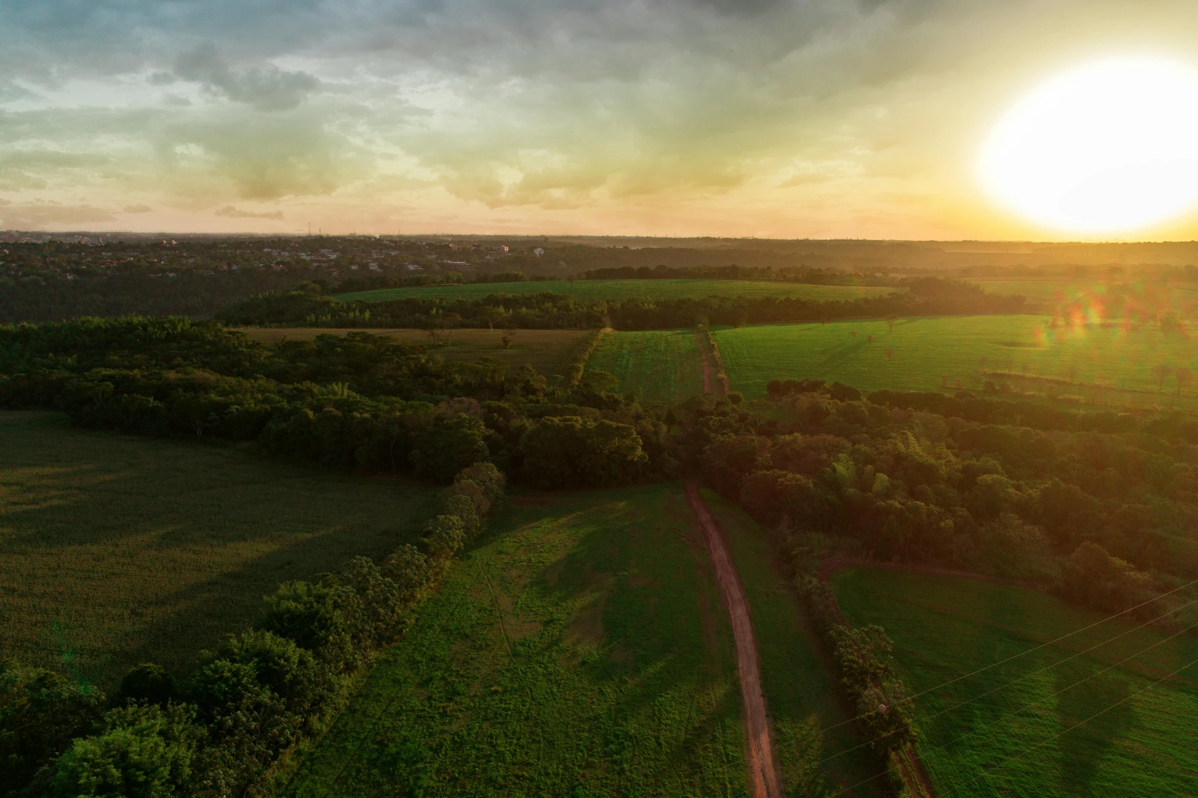 the sun is shining in the sky over a large field