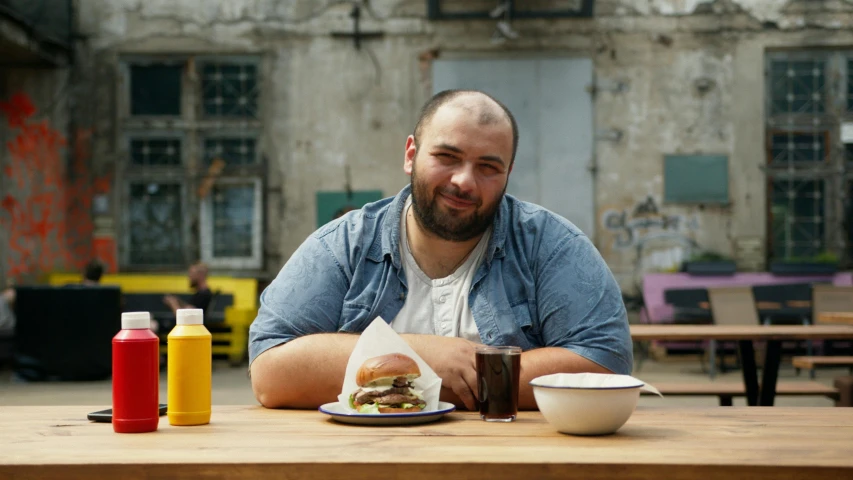 a man sitting at a table with his hand on his stomach