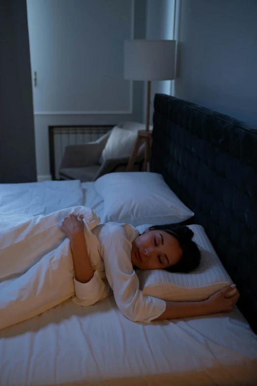 a woman laying on top of a bed with pillows