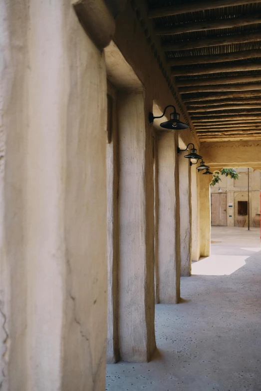 an empty hallway is lined with white concrete pillars