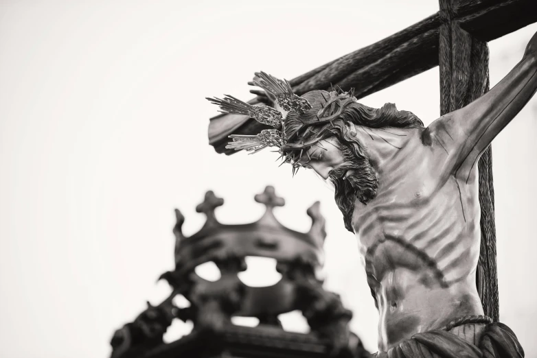 a statue of jesus is holding the cross