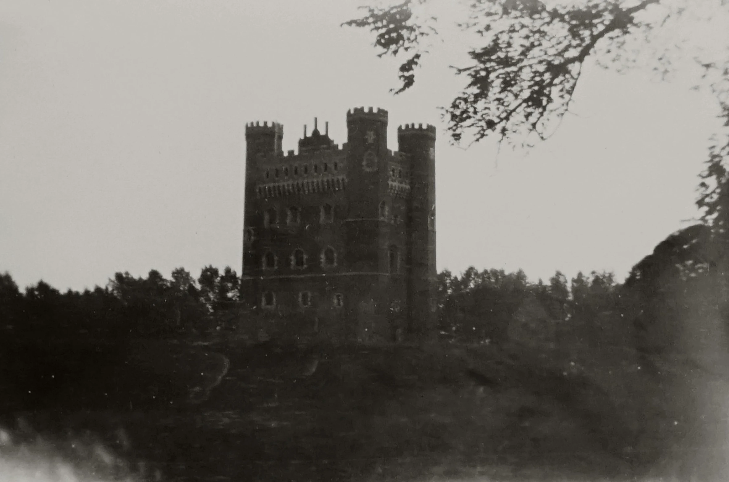 an old black and white po of a castle surrounded by trees