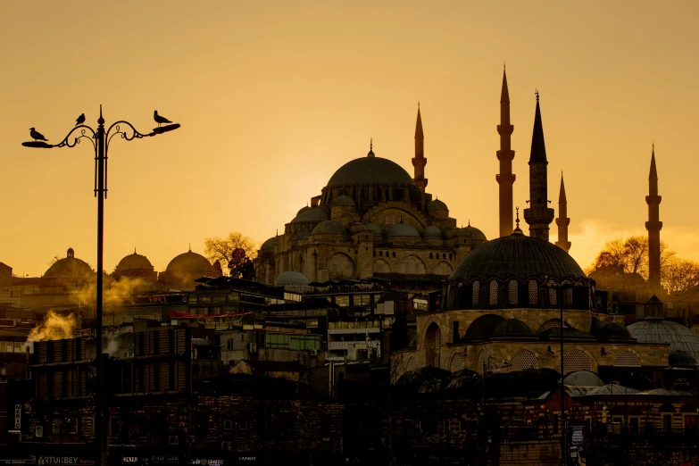 the sun rises over a city with large buildings